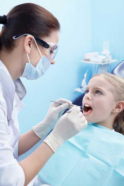 Lady dentist checking a girl