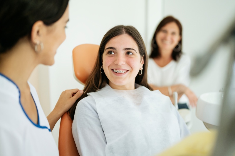 A dentist giving oral care tips to a child with braces during a visit in the Westlake, OH clinic