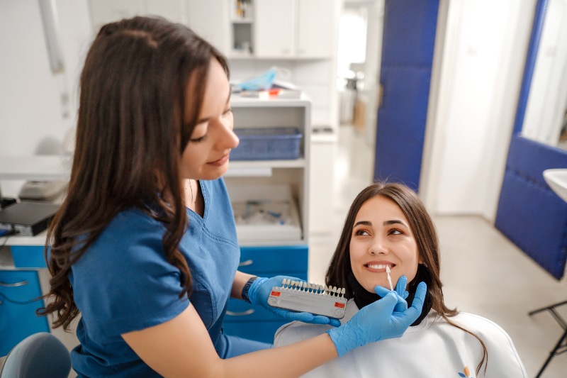 Dental professional checking patient veneers using shade guide clinic, Westlake, OH