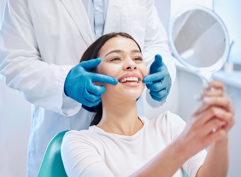 Smile makeover consultation with a dentist reviewing teeth using a mirror in Westlake, OH